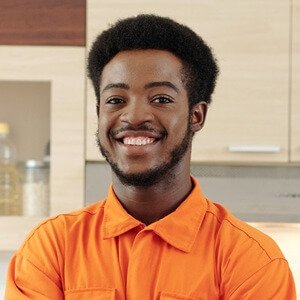 cheerful afro american plumber at kitchen 5lvq5px.jpg
